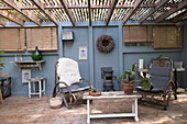 Covered terrace with rattan furniture and wood-burning stove