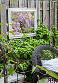Mirror design in the garden with lush foliage and rattan chair