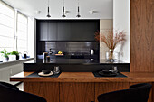 Modern kitchen with wooden accents and black fronts in Warsaw
