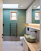 Hellgrüne Kacheln und modernes Waschbecken im Badezimmer