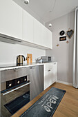 Modern kitchenette with stainless steel appliances in a flat in Warsaw