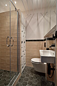 Modern gestaltetes Badezimmer mit Duschkabine und Wandfliesen in Beigetönen