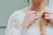 Braut in einem weißen Hochzeitskleid mit Spitzenapplikationen