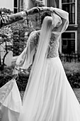Braut im weißen Kleid tanzt mit Partner im Freien