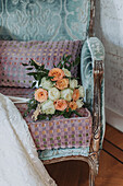 Bouquet of roses and eucalyptus on antique chair with velvet upholstery