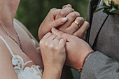 Braut und Bräutigam zeigen Eheringe an den Händen