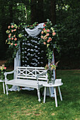 Dekorierte weiße Holzbank für Hochzeit im Garten