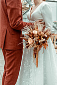 Bridal couple with autumn bridal bouquet of dried flowers, vintage style