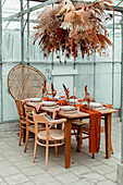 Dining table set with dried flowers in a greenhouse