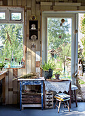 Summer garden shed with wooden decor, plants and decorative items at the window