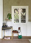 Desk with gold-coloured frame, white cabinet with leaded glass windows