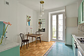 Brightly furnished kitchen with wooden floor, dining area and colour accents