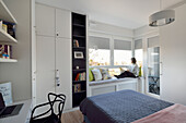 Modern eingerichtetes Schlafzimmer mit Person am Fenster