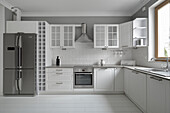 Moderne Küchenzeile mit Edelstahlgeräten und weißen Wandfliesen
