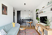 Hell gestalteter Wohnraum mit integrierter Küche und Essbereich