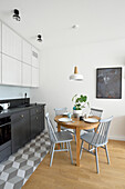 Moderne Küche mit Holz-Esstisch und Stühlen in Grautönen