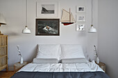 Maritimes Schlafzimmer mit Modellschiff und Segelbildern an der Wand