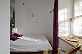 Schlafzimmer mit Holzmöbeln und violetten Akzenten
