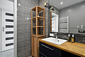 Modernes Badezimmer mit Holzdetails und grauen Fliesen