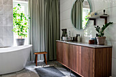 Modern bathroom with free-standing bathtub and wooden furniture