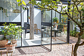 Conservatory with glass walls, fireplace and plants