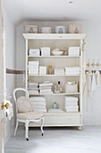 Open cupboard with towels and bathroom utensils