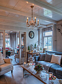 Living room decorated for Christmas with vintage chandelier, wooden beamed ceiling and candles