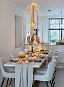 Table setting and ceiling lamp with fairy lights in a modern dining room