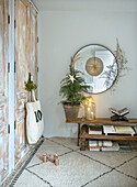 Room with round mirror and rustic cabinet