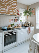 Bright kitchen with white base units and patterned wall units