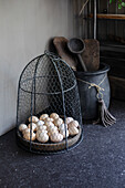 Wire basket with eggs on a black worktop in a rustic kitchen