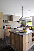 Kitchen with wooden fronts, kitchen island and stone floor