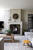 Living room with fireplace, large rug and wooden table