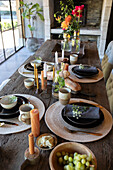 Rustic dining table with candles, flowers and place settings