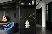 Modernes Apartment in Schwarz mit skulpturaler Vase und Grünpflanze