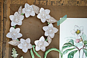 DIY paper flower wreath with green accents and watercolour drawing