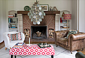 Living room with patterned table and leather armchair in front of brick fireplace