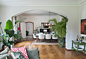 Open-plan dining and living area with herringbone parquet flooring and plants