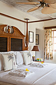 Bedroom with wood paneling, tropical accents and ceiling fan