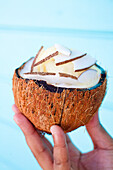 Half of a coconut filled with coconut meat and ice cream