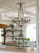 Crystal chandelier above kitchen island with antique lantern