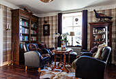 Rustic living room with leather chairs, wooden table and checkered wallpaper