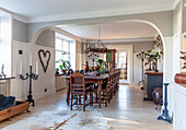 Country-style dining room with rustic wooden table, old wooden chairs and candlesticks