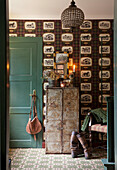 Entrance area with vintage wallpaper, metal chest of drawers and green wooden door