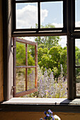 Open wooden windows with a view of the flowering summer garden