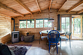 Cosy wooden hut with round table, chairs and stove