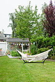 Hammock in the garden next to a decorated garden shed