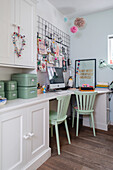 Home office with green chairs, cupboards and decorative wall grid