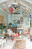 Colourful garden shed with wicker furniture and vintage-style lamps