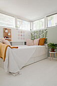 Bedroom with bed, plant decoration and perforated board